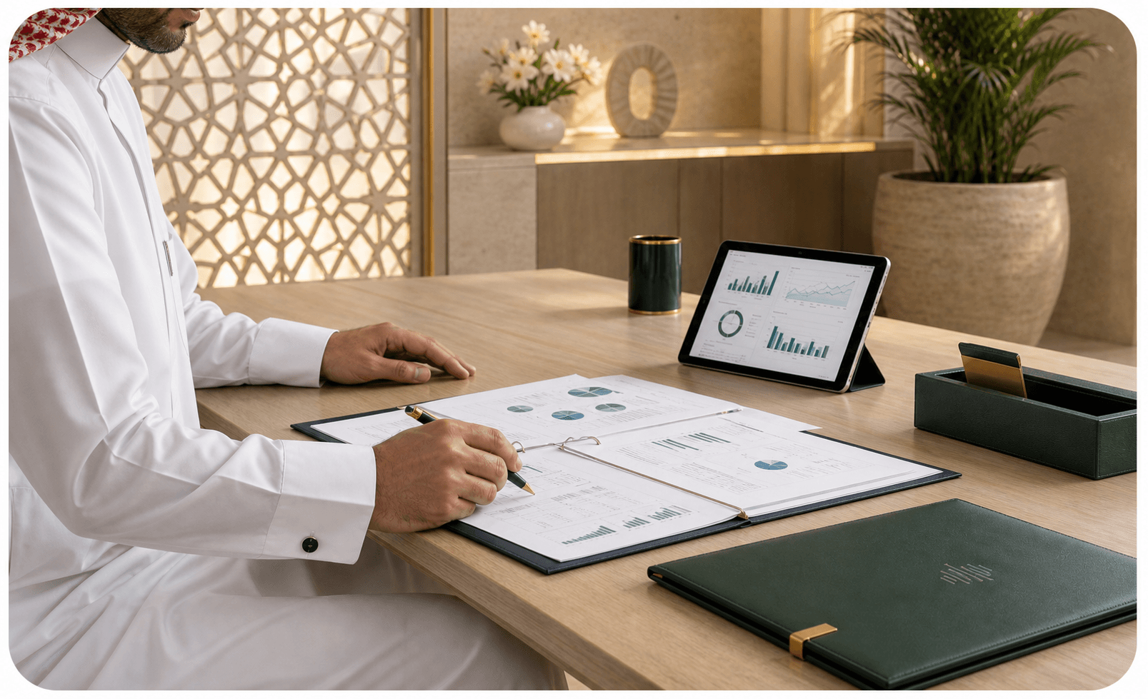 Saudi financial professional reviewing reports beside a financial dashboard